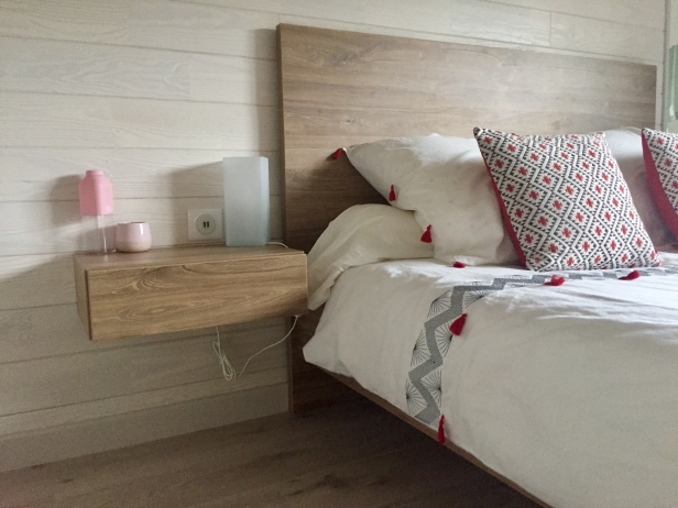 Détails du lit, table de chevet, parquet et pan de mur en bois par déco-mag